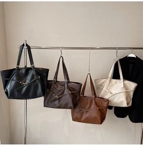 Detail of four chic tote bags in black, coffee, caramel and white on a display rack