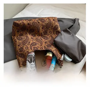 Macro detail of large paisley tote bag interior capacity with matching small zipper pouch