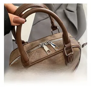 Detail of vintage tote bag showing dark denim texture with brown leather and silver zippers