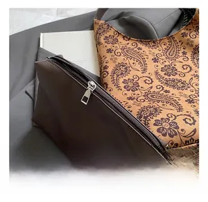 Close-up of polished silver metal zipper on a dark brown waterproof nylon cosmetic pouch