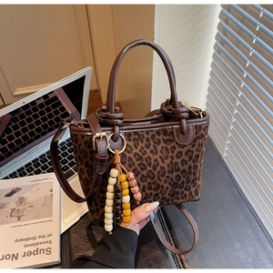 Borsa a secchiello leopardata con manici in pelle e nappa con perline colorate