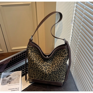 Close-up of a large leopard print bucket bag with brown trim in a stylish office setting