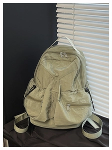 Detail view of water-resistant green nylon outdoor backpack with side drawstring pockets