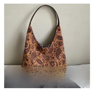 Detail showing the brown paisley patterned fabric and slim strap of the hobo tote bag
