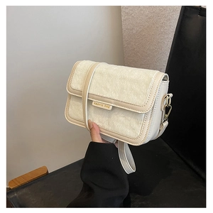 Détail du sac bandoulière en peluche avec fourrure crème et bandoulière réglable