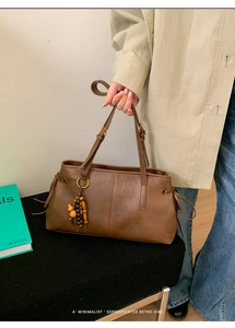Detail of vintage brown tote bag with decorative ethnic wooden beads and side drawstrings