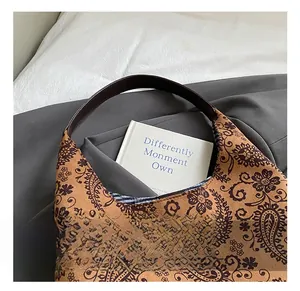 Detail view of the brown paisley hobo bag featuring premium leather handles and floral patterns