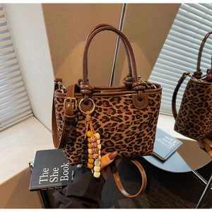 Dettaglio della borsa tote leopardata con manici in pelle marrone e nappa di perline