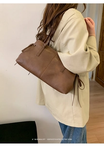 Detailed side view of large brown retro tote bag with minimalist leather strap accents