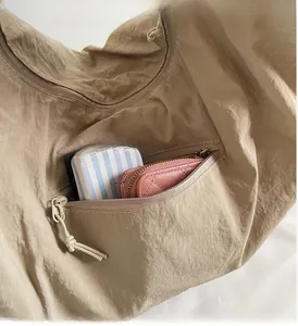 Vue détaillée du sac cabas kaki montrant la poche intérieure zippée et le rangement