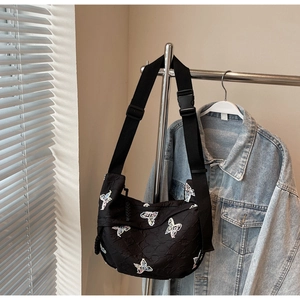 Close-up of black quilted canvas hobo bag with colorful butterfly embroidery details