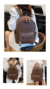 Detail showing woven texture brown leather backpack with silver bear charm and zipper pocket