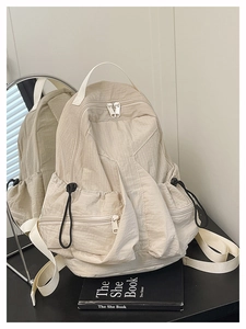 Close-up of beige nylon backpack with textured grid fabric and adjustable drawstrings
