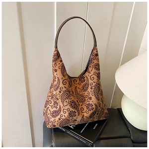 Detail of hobo bag showing retro brown paisley pattern and premium leather handle