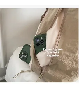 Détail du sac bandoulière en nylon kaki montrant une poche zippée et sa grande capacité