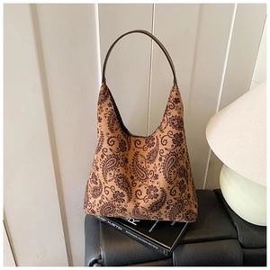 Detailed view of paisley patterns on a vintage canvas tote bag with brown handle