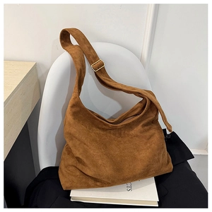 Vue détaillée du sac hobo en daim marron avec bandoulière large et boucle en métal