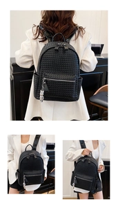 Detail view of black woven leather backpack with silver bear charm and front zipper pocket