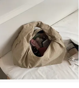 Vue détaillée de l'intérieur spacieux d'un sac cabas kaki contenant parapluie et mobile