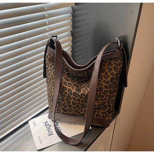 Close-up of leopard print tote bag with leather trim and wide adjustable shoulder straps