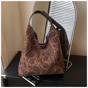 Detail view of large brown paisley hobo bag with striped lining and retro aesthetic