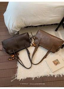 Detailed view of dual vintage tote bags with wooden bead tassels on a soft white carpet