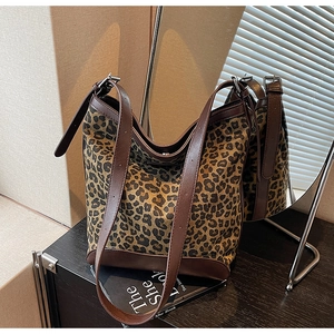 Detail of leopard print bucket bag with leather reinforced base and double straps