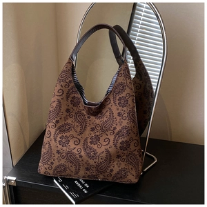 Detail of vintage paisley pattern canvas tote bag with brown straps and striped lining