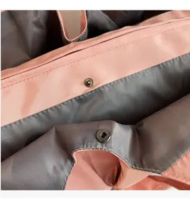 Détail du bouton pression en métal sur un sac en nylon brillant rose et gris chic