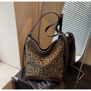 Detail of leopard print bucket bag with premium leather trim and adjustable strap