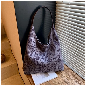 Detail of greyish-purple paisley canvas tote bag featuring premium leather strap