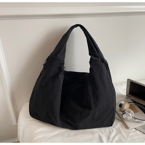 Détail de la texture plissée en nylon et de la large bandoulière du sac hobo noir spacieux