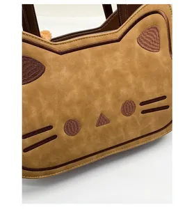 Close-up of cat-shaped handbag featuring embroidered whiskers and ears on brown faux leather
