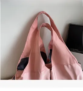 Détail du sac cabas rose en nylon montrant la poignée large et la texture lisse