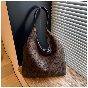 Close-up of vintage paisley pattern on a large brown canvas tote bag with leather strap