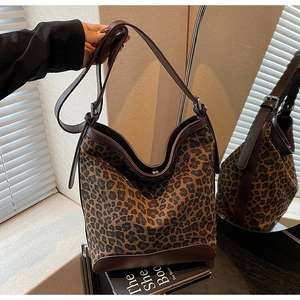 Close-up of leopard print bucket bag with brown leather details and shoulder strap