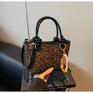 Dettaglio della borsa leopardata con manici in vernice e ciondolo con perline colorate