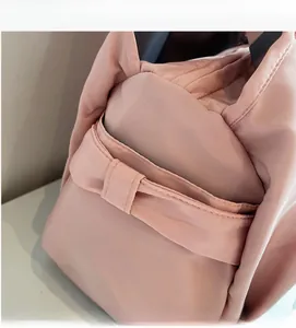 Gros plan du sac fourre-tout en nylon rose montrant le tissu doux et le nœud