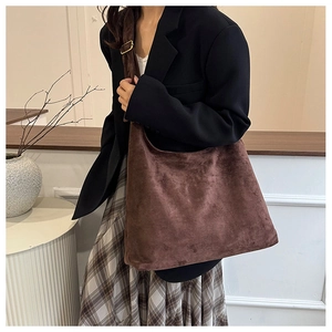 Détail du sac fourre-tout en daim café avec bandoulière large et boucle en métal doré