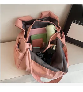 Intérieur du grand sac de voyage rose montrant des compartiments pour divers accessoires