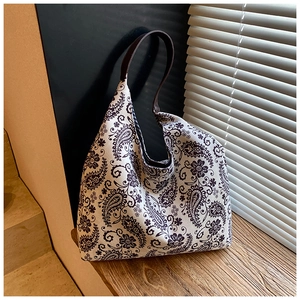 Detailed close-up of large paisley pattern canvas tote bag on rustic wooden steps