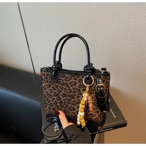 Dettaglio della borsa a secchiello leopardata con perline e tracolla nera