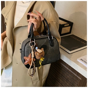 Detail of vintage grey pillow bag with cute plush bear charm and star leather pendant