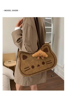 Detail shot of a creative cat-shaped shoulder bag with a cute plush croissant charm