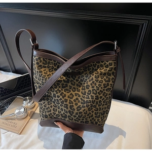 Close-up of leopard print bucket bag with leather base and sturdy shoulder strap