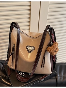 Large capacity color-block bucket bag with metallic triangle logo and plush bear charm