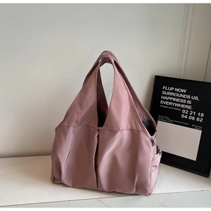Détail macro du sac cabas en nylon rose poudré avec poche latérale et fermeture à glissière
