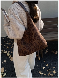 Retro paisley tote bag shown in a lifestyle outdoor setting on a wooden bench