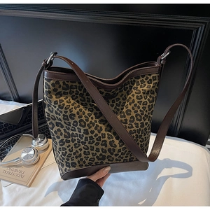 Macro shot of stylish leopard print bucket bag with dark brown leather detailing