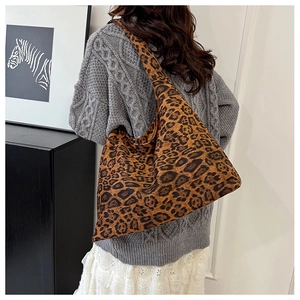 Détail du sac cabas en toile à imprimé léopard porté par un mannequin en tenue décontractée